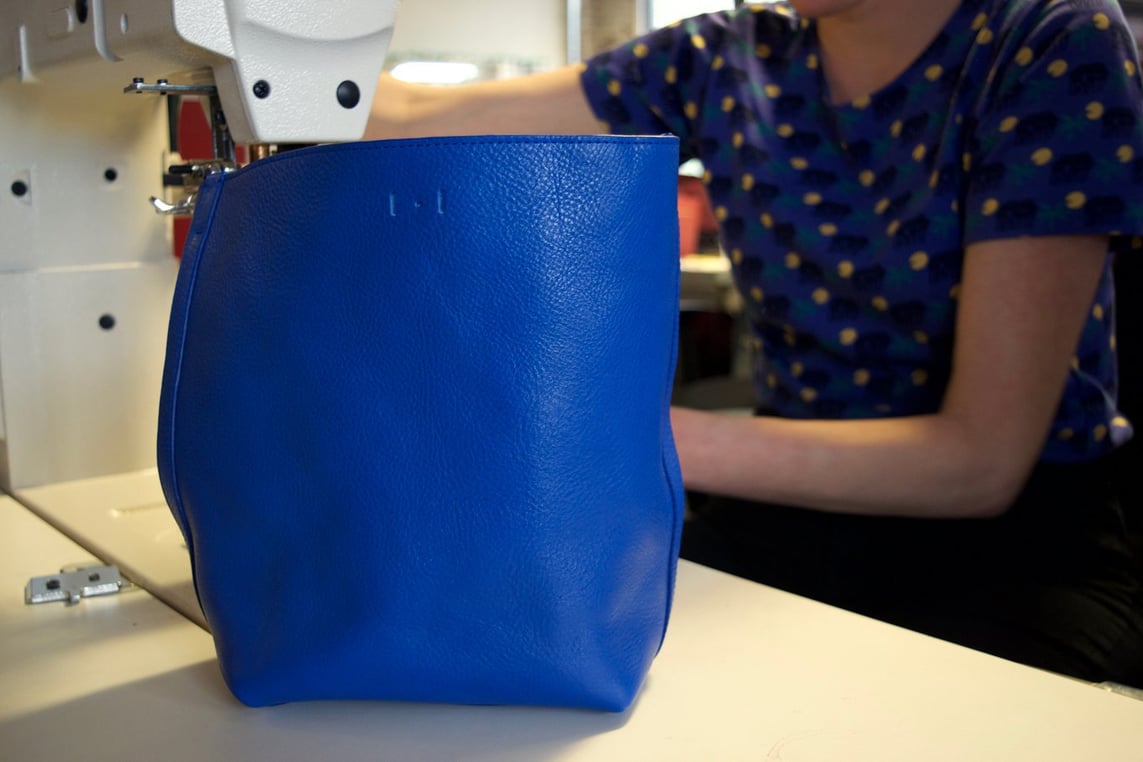 Stitching the Lotuff Leather Mini Sling backpack in electric blue
