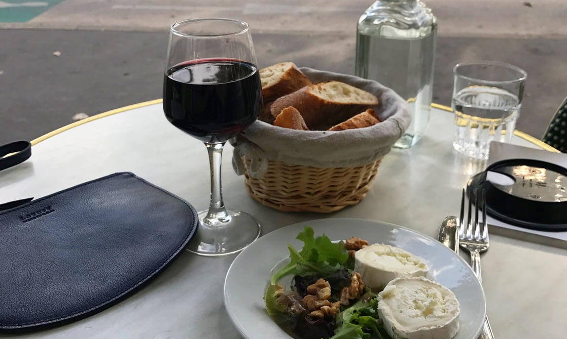 Wine break at a Paris café with a Lotuff Leather Round Pouch in indigo