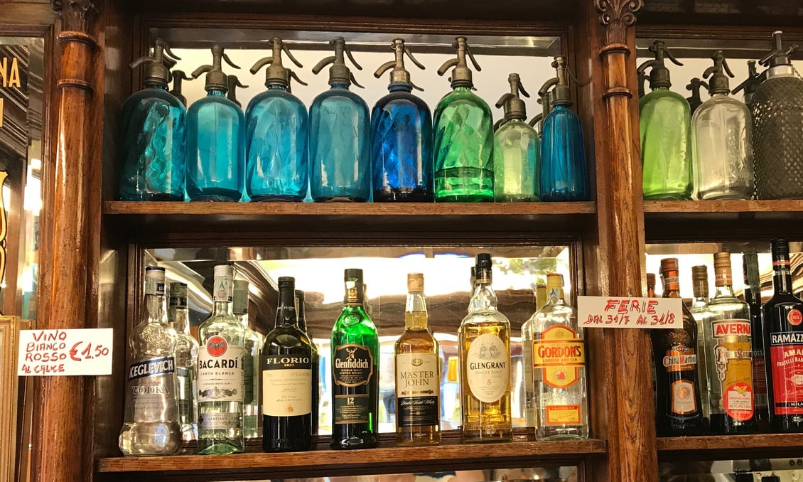 Colored glass bottles behind a bar in Florence